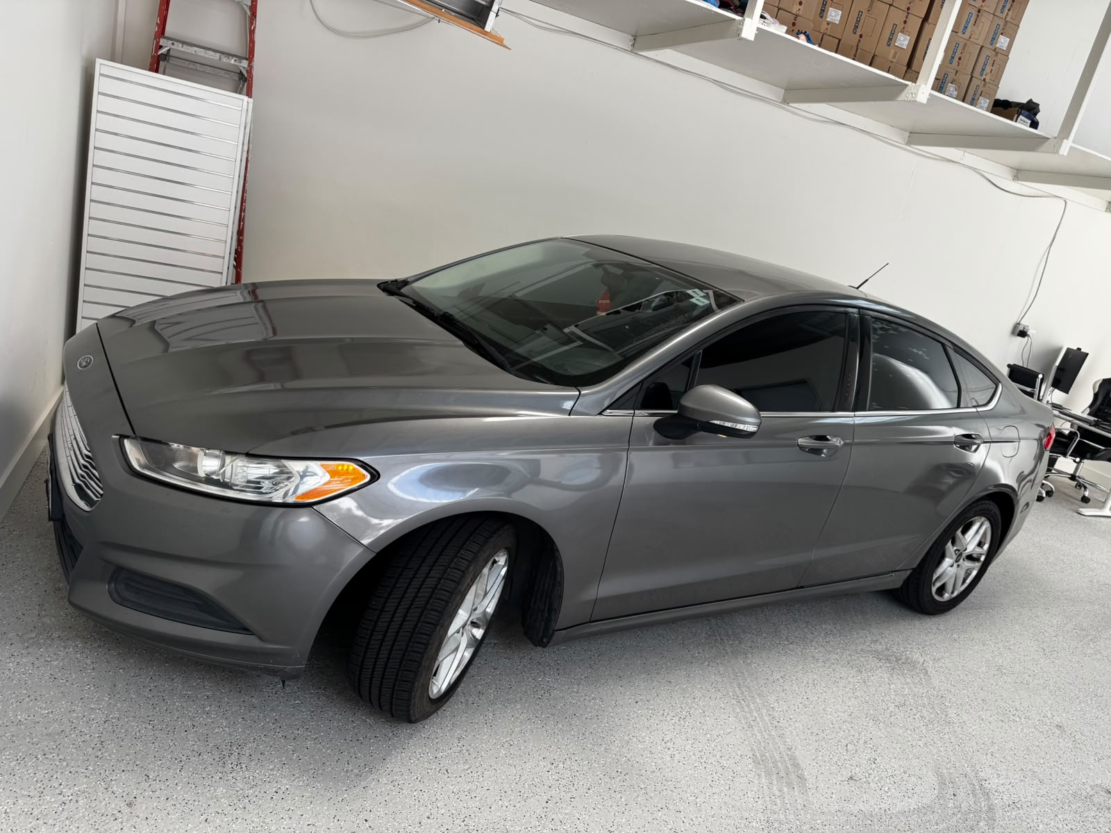 Gray 2014 Ford Fusion Hybrid parked indoors at PeakDeal Auto Sales